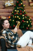 dziewczyna czyta książkę na tle choinki naściennej